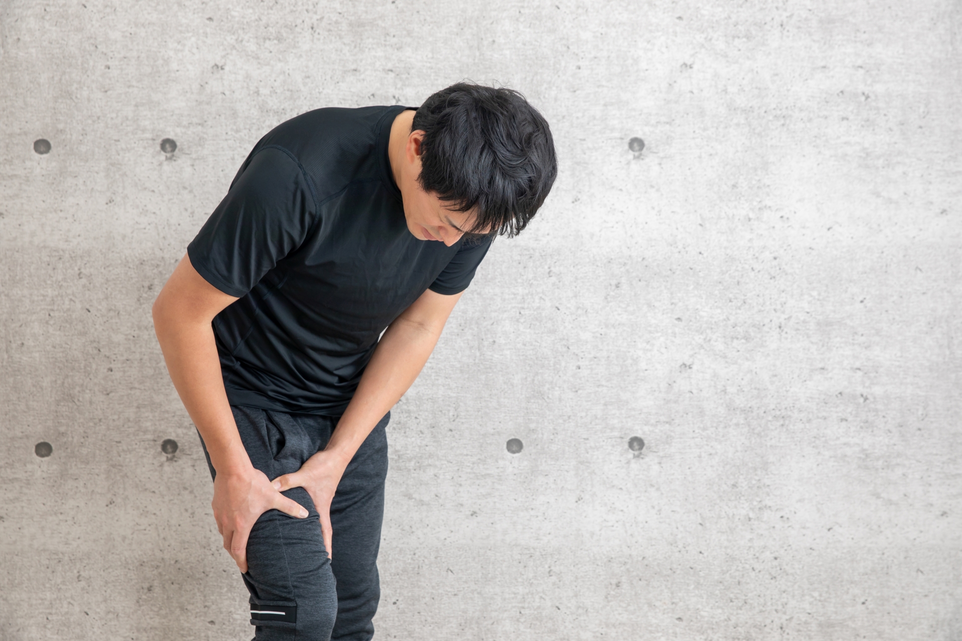 太ももを押さえる男性